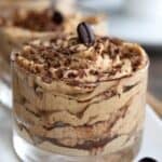 Titles image of a glass dessert dish filled with Keto Tiramisu Protein Mousse on a white tray.