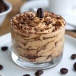 Tiramisu Protein Mousse in a glass dessert dish with chocolate shavings and an espresso bean on top.