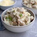 Close up shot of a bowl filled with creamy chicken and parmesan cauliflower rice.