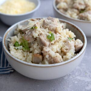Close up shot of a bowl filled with creamy chicken and parmesan cauliflower rice.