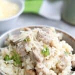 Titled image close up of a bowl filled with creamy chicken and cauliflower rice.