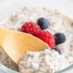 Titled image of a wooden spoon digging into a jar of keto overnight oats topped with fresh berries.